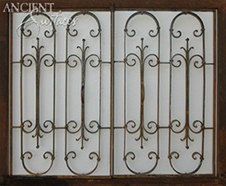 Antique hand forged fireplace metal gates crafted out of original entryway iron gates and doors.