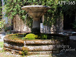 antique stone fountain in the courtyard with planters